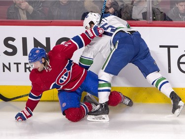 Montreal Canadiens defenceman Tom Gilbert, left, is checked into the boards by Vancouver Canucks right wing Derek Dorsett during second period National Hockey League action Monday, November 16, 2015 in Montreal.