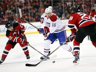 Montreal Canadiens left wing Tomas Fleischmann (15), of the Czech Republic, skates against New Jersey Devils right wing Jordin Tootoo (22) and defenceman Damon Severson (28) during the first period of an NHL hockey game Friday, Nov. 27, 2015, in Newark, N.J.