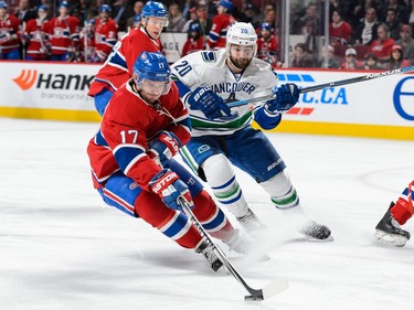 Torrey Mitchell #17 of the Montreal Canadiens protects the puck against Chris Higgins #20 of the Vancouver Canucks during the NHL game at the Bell Centre on November 16, 2015 in Montreal, Quebec, Canada.