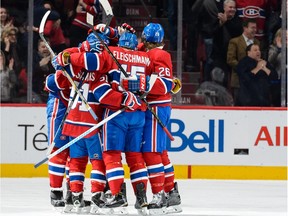 Tomas Fleischmann #15 of the Montreal Canadiens celebrates his goal with teammates after tying the game in the third period during the NHL match against the Vancouver Canucks at the Bell Centre on November 16, 2015 in Montreal, Quebec, Canada.  The Canadiens defeated the Canucks 4-3 in overtime.
