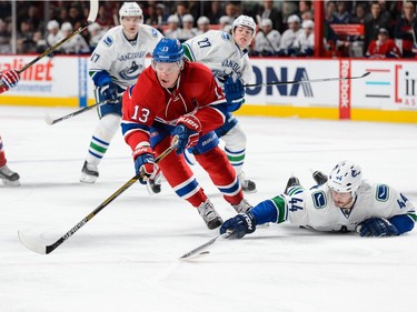 Matt Bartkowski #44 of the Vancouver Canucks defends the puck from the ice against Alexander Semin #13 of the Montreal Canadiens during the NHL game at the Bell Centre on November 16, 2015 in Montreal, Quebec, Canada.