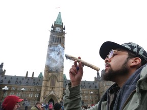 Shawn enjoys his big joint on Parliament Hill in Ottawa during the 420 gathering to protest the continued prohibition of marijuana, April 20, 2015.  (Jean Levac/ Ottawa Citizen)