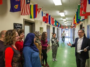 Volunteers receive a tour by Norman Paris, right, coordinator for the Service de la organisation scolaire, during a briefing on how to assist and accommodate the children of Syrian refugee families at the Commission scolaire de Montréal (CSDM) headquarters in Montreal on Tuesday, Dec. 8, 2015.