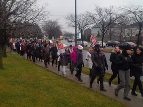 Members of the Fédération Autonome de l'Enseignement march to  the offices of Treasury Board President Martin Coiteux in Kirkland on Dec. 10, 2015.