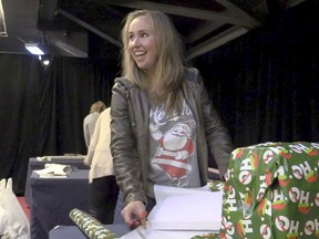 Julie Petry, who is married to Jeff Petry of the Montreal Canadiens, wraps gifts for  underprivileged youngsters as part of the team's annual Opération Père Noël program at the Bell Centre in Montreal Tuesday, Dec. 15, 2015.