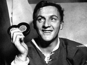 Dickie Moore with a couple of pucks, representing two goals he had scored for the mid-1950s Montreal Canadiens.