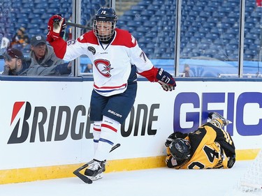 Denna Laing #24 of the Boston Pride (NWHL) is injured as she hits the boards as Karell Emard #76 of the Les Canadiennes (CWHL) skates away from the play during the Outdoor Womens Classic at Gillette Stadium on December 31, 2015 in Foxboro, Massachusetts.