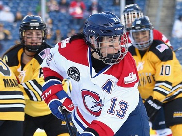 Caroline Ouellette #13 of the Les Canadiennes (CWHL) carries the puck against the Boston Pride (NWHL) during the Outdoor Womens Classic at Gillette Stadium on December 31, 2015 in Foxboro, Massachusetts.