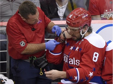 Washington Capitals left wing Alex Ovechkin (8), of Russia, gets treatment on his arm during the third period of an NHL hockey game against the Montreal Canadiens, Saturday, Dec. 26, 2015, in Washington. At right is Washington Capitals center Nicklas Backstrom, of Sweden. The Capitals won 3-1.