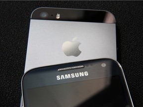 LONDON, ENGLAND - AUGUST 06:  A Samsung and Apple smartphone are displayed on August 6, 2014 in London, England. Smartphone and tablet manufacturers Samsung and Apple have agreed to end all legal cases over patent infringements outside of the US.