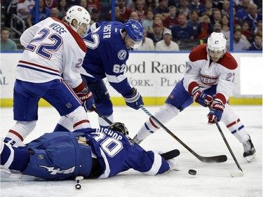 Tampa Bay Lightning goalie Ben Bishop (30) dives and knocks the puck away on a shot by Montreal Canadiens center Alex Galchenyuk (27) during the first period of an NHL hockey game Monday, Dec. 28, 2015, in Tampa, Fla. Canadiens right wing Dale Weise (22) and Lightning defenseman Andrej Sustr (62), of the Czech Republic, look for a rebound,