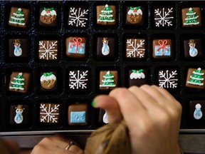 Members of the icing team decorate by hand festive biscuits and cakes at the Biscuiteers biscuit company in south London on December 8, 2015. The company has so far used 13,500kg of dough, 30,000 icing bags and 7,225kg of icing fulfilling Christmas orders.