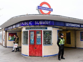 A police officer stands guard outside Leytonstone station in north London on December 6, 2015, a day after three people were stabbed in what police are treating as a "terrorist incident".