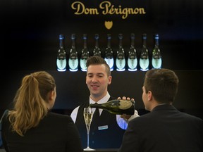 Mickael Raymond pours a glass of 2004 Brut vintage Dom Pérignon at the classy Dom Pérignon Champagne Bar at the Ritz-Carlton Hotel. The dramatically lit gold-labelled bottles are a focal point in this glitzy space.