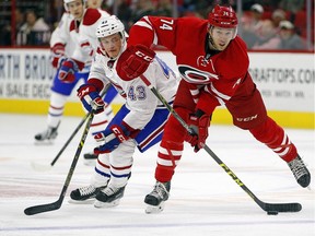Carolina Hurricanes' Jaccob Slavin looks to clear the puck in front of Canadiens' Daniel Carr during the first period of an NHL hockey game, Saturday, Dec. 5, 2015, in Raleigh, N.C.