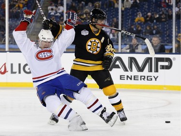 Former Montreal Canadiens' Donald Audette, left, falls after an infraction by former Boston Bruins' Don Sweeney, right, during an Alumni outdoor hockey game at Gillette Stadium in Foxborough, Mass., Thursday, Dec. 31, 2015, where the Bruins will play the Canadiens in the NHL Winter Classic on Friday.