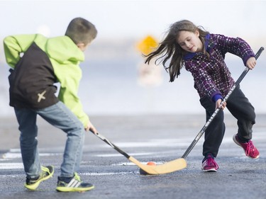 Emile Castonguay and his sister Adele, right, play a game of ball hockey, on Thursday, Dec. 24, 2015.