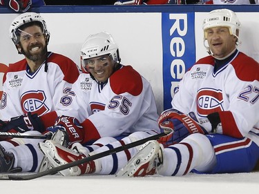 Former Montreal Canadiens' Eric Desjardins, left, Francis Bouillon, center, and Alexei Kovalev, right, sit on the ice during a shoutout in the Alumni outdoor hockey game at Gillette Stadium against former Boston Bruins players in Foxborough, Mass., Thursday, Dec. 31, 2015, where the Bruins will play the Canadiens in the NHL Winter Classic on Friday.