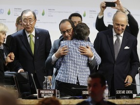 Executive Secretary of the United Nations Framework Convention on Climate Change (UNFCCC) Christiana Figueres (C-R) and France's President Francois Hollande (C-L) hug after the adoption of a historic global warming pact at the COP21 Climate Conference in Le Bourget, north of Paris, on December 12, 2015. Envoys from 195 nations on December 12 adopted to cheers and tears a historic accord to stop global warming, which threatens humanity with rising seas and worsening droughts, floods and storms.