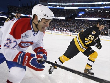 Former Montreal Canadiens' Gilbert Delorme (27) and former Boston Bruins' Glen Wesley (26) chase after the puck during an alumni outdoor hockey game at Gillette Stadium in Foxborough, Mass., Thursday, Dec. 31, 2015, where the Bruins will play the Canadiens in the NHL Winter Classic on Friday.