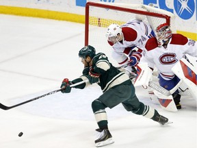 Wild's Jason Pominville, left, races to the puck before shooting and scoring on Canadiens goalie Mike Condon as defenceman Alexei Emelin looks on helplessly from the crease Tuesday night in St. Paul, Minn.