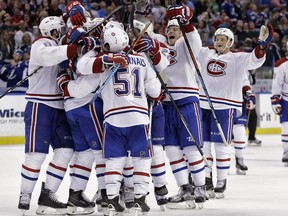 Members of the Montreal Canadiens mob Max Pacioretty after his goal against the Tampa Bay Lightning during the shootout in an NHL hockey game Monday, Dec. 28, 2015, in Tampa, Fla. The Canadiens won 4-3.