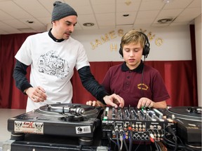 DJ Cosmo, left, helps student Colby Ross, right, with scratching rudiments at James Lyng High School, on Friday Dec. 4, 2015 in Montreal. James Lyng is transforming itself into an urban arts high school with support from McGill University's Department of Integrated Studies in Education. Students are offered specialized instruction in song-writing, rapping, music production, instrumental music and graffiti arts. In addition, visual arts and music are being integrated into more traditional academic subjects, such as French and Math.