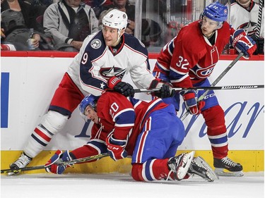 Montreal Canadiens Christian Thomas is held down by Columbus Blue Jackets  Gregory Campbell while Habs Brian Flynn watches during first period of National Hockey League game in Montreal Tuesday December 1, 2015.