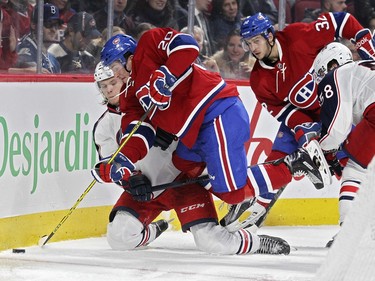 Montreal Canadiens Christian Thomas is tripped by Columbus Blue Jackets David Savard, right, while being checked by Jackets William Karlsson, left, in front of Habs Brian Flynn during third period of National Hockey League game in Montreal Tuesday December 1, 2015.