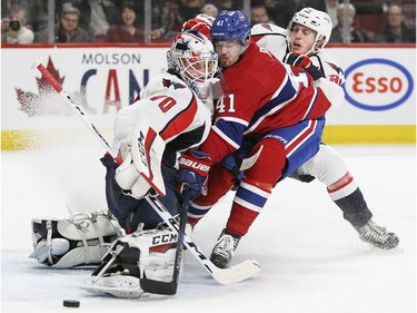 Montreal Canadiens Paul Byron crashes into Washington Capitals goalie Braden Holtby after shooting the puck wide  of the net while being checked by Capitals Nate Schmidt during National Hockey League game in Montreal Thursday December 3, 2015.