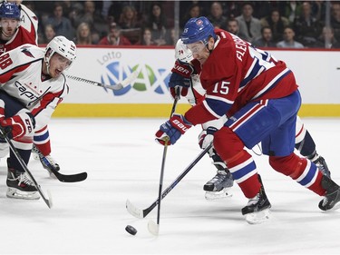 Montreal Canadiens Tomas Fleischmann drives the puck to the Washington Capitals net while being defended by Capitals Nate Schmidt, left, and John Carlson as Habs Paul Byron watchs during National Hockey League game in Montreal Thursday December 3, 2015.