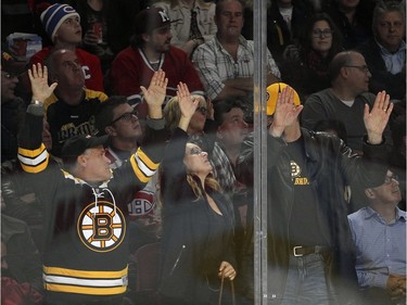 Boston Bruins fans bang on the glass in celebration of their team's winning goal during third period of National Hockey League game against the Montreal Canadiens in Montreal Wednesday December 9, 2015.
