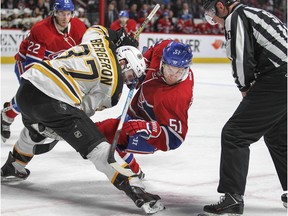 Montreal Canadiens David Desharnais falls while taking faceoff against Boston Bruins Patrice Bergeron during first period of National Hockey League game in Montreal Wednesday December 9, 2015. Habs Dale Weise, 22, waits for puck.