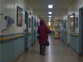 A woman carries flowers as she walks down the corridor towards a room at the palliative care centre at Maisonneuve-Rosemont hospital.
