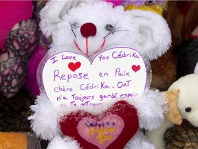 A note sits among stuffed toys and flowers next to a trail in St Maurice east of Trois-Rivières, Dec. 14, 2015, near the site where the remains of Cédrika Provencher were found.