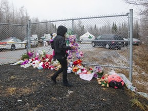 A woman brngs a stuffed toy to add to others and the flowers near the site where the remains of Cédrika Provencher were found Dec. 14, 2015.
