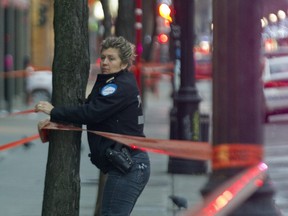 Montreal police erect a cordon at the scene of a fatal stabbing outside a bar on Ste-Catherine St. near Fort St. Dec. 18, 2015.