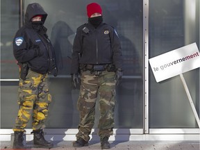 In 2014, Montreal police keep watch as city of Montreal workers cross a picket line past striking colleagues during a 24-hour strike by the city's white collar workers.