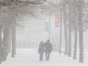 Dominique Gaudreault and Yves Giroux, right, take in the blustery scene along the Lachine Canal. Environment Canada expects a total of 30 centimetres of snow by the time the storm is done.