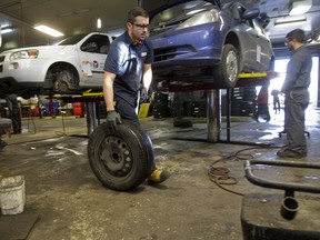 File photo: Merson Automotive mechanics Jonathan Lasry, left, and Tyler Delisi change winter tires for clients at the garage in NDG, on Tuesday Nov. 18, 2014.