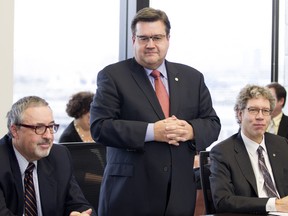 Denis Coderre, centre, mayor of Montreal, convenes a planning meeting in Montreal Nov.19, 2015. Michel Dorais, left and Russell Copeman listen in.