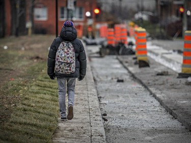 A boy walks down the narrow sidewalk that has been constructed along the west side of Brebeuf St. next to Sir Wilfrid Laurier Park in the Plateau-Mont Royal borough in Montreal Monday November 30, 2015.