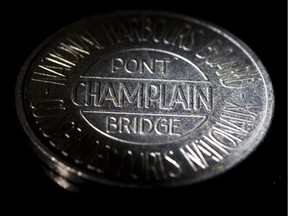 An old Champlain Bridge toll token photographed at The Gazette studio in Montreal on Monday, October 17, 2011. The federal Liberals say there won't be a toll on the new Champlain Bridge, but that doesn't mean you won't be paying extra for it anyway - and not just in cash. (Dario Ayala/THE GAZETTE)