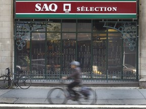 A cyclist passes by the SAQ selection on the Maisonneuve Blvd. in downtown Montreal.