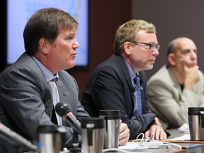 File photo: Former Société de Transport de Montréal director general Carl Desrosiers, left, answers questions while sitting next to board chairman Philippe Schnobb and vice chair Marvin Rotrand, right, during a public board meeting in Montreal Wednesday Sept. 3, 2014.