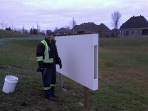 Municipal worker installs a white board at Parc des Éperviers in Notre-Dame-de-l'Ile-Perrot for graffiti artists to use instead of targeting building walls.