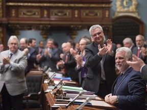 Quebec Premier Philippe Couillard, right, is applauded by members of the legislature after he gave his holiday greetings. The government's plan to increase MNA salaries is a wrong-headed, tone-deaf course of action at which Quebecers can justifiably be annoyed, Basem Boshra writes.