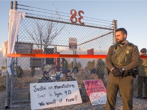 Police watch over two demonstrators locked to a valve along Enbridge pipeline 9B on Monday, Dec. 7 in Ste-Justine-de-Newton, near the Ontario border.