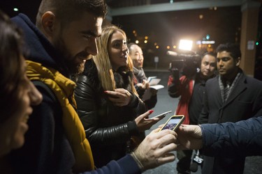 Syrian George Bytion, left, is shown a photo by a reporter of a refugee arriving, along with with other Syrian refugees arriving on the first government-arranged flight into Toronto's Pearson Airport as they wait to greet their soon-to-arrive cousins at a nearby hotel, on Friday, Dec. 11, 2015.
