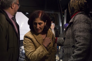 A Syrian refugee steps off a bus into a hotel after arriving on the first government-arranged flight into Toronto's Pearson Airport.